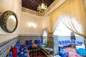 - un salon avec des canapés bleus et un miroir dans l'établissement Riad Mounana, à Fès