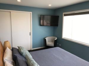 a bedroom with a bed and a television on the wall at Gerding Haven in Napier