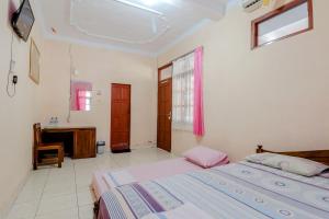 a bedroom with two beds and a desk in it at Hotel Kukup Indah in Kemadang