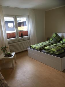 Schlafzimmer mit einem Bett mit grüner Bettwäsche und einem Fenster in der Unterkunft Töff - Töff in Willingen