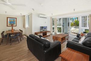 a living room with a couch and a table at The Bay Apartments Coolangatta in Gold Coast