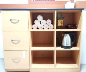 a wooden bookcase with drawers and a coffee maker at Healinghouse Peakjang in Buyeo