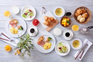 a table with plates of breakfast foods and drinks at Hotel Keihan Universal Tower in Osaka