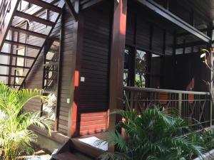 ein Holzhaus mit einer roten Tür und einigen Pflanzen in der Unterkunft Linda Beach Hotel in Nusa Lembongan