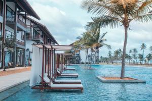 una piscina con palme presso il resort di Anantaya Resort & Spa Chilaw a Chilaw