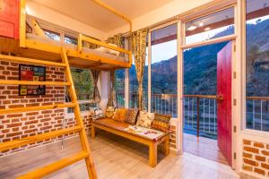 a room with a bunk bed and a bench at Zostel Plus Mussoorie- Kempty in Mussoorie