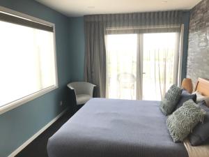 a bedroom with a bed and a large window at Gerding Haven in Napier