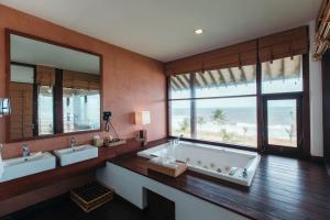 un bagno con due lavandini e una vasca con vista sulla spiaggia di Anantaya Resort & Spa Chilaw a Chilaw