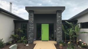 una porta verde sul lato di una casa di Gerding Haven a Napier