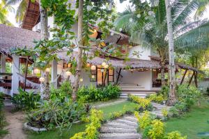 a house with a garden in front of it at Casa Bianca Siargao in General Luna