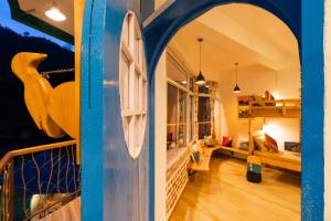 a room with a blue door and a bedroom at Zostel Plus Mussoorie- Kempty in Mussoorie