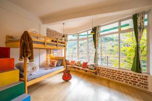 a bedroom with bunk beds and a large window at Zostel Plus Mussoorie- Kempty in Mussoorie