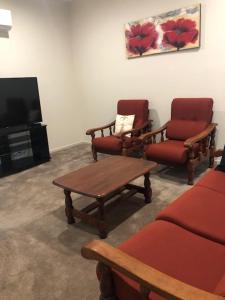 a living room with two chairs and a tv at Central executive 4br townhouse in Albury