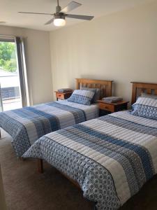 a bedroom with two beds and a ceiling fan at Central executive 4br townhouse in Albury