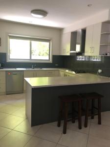 a kitchen with a counter and two stools in it at Central executive 4br townhouse in Albury