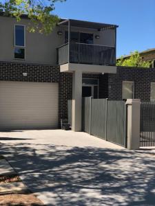 una casa con una valla y un garaje en Central executive 4br townhouse, en Albury