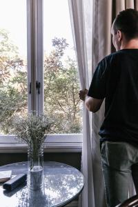 un hombre mirando por una ventana a una mesa en The Lurline Randwick, en Sídney