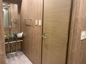 a bathroom with a wooden door and a sink at My DearⅠ in Osaka