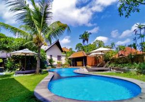 a swimming pool in front of a villa at Pondok Massas Ubud in Ubud