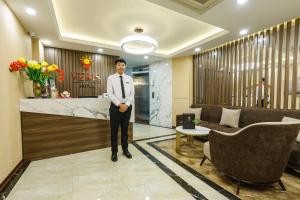 a man in a suit and tie standing in a lobby at Hanoi Veris Boutique Hotel & Spa in Hanoi