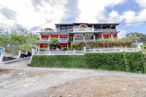 班圖爾的住宿－Adinda Beach Hotel and Villa，一座橙色房子,前面有白色的围栏