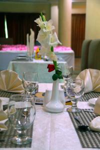 una mesa con un jarrón blanco con una flor. en Hotel One Abbottabad, en Abbottābād