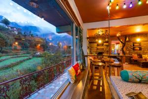 a room with a balcony with a view of a mountain at Zostel Plus Mussoorie- Kempty in Mussoorie