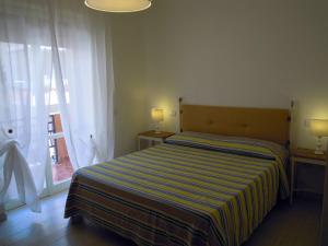 ガリポリにあるB&B Palazzo Belvedereのベッドルーム1室(ストライプ毛布、窓付)