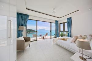 una camera con letto e vista sull'oceano di BEACHSIDE VILLA - B18 - at Bayside Luxury Villas Samrong Bay Beach, 4 BED 5 BATH, SEA & SUNSET VIEWS, only 200m walk to the Beach a Choeng Mon Beach