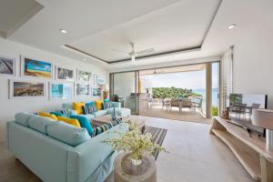 ein Wohnzimmer mit blauen Sofas und Meerblick in der Unterkunft BEACHSIDE VILLA - B18 - at Bayside Luxury Villas Samrong Bay Beach, 4 BED 5 BATH, SEA & SUNSET VIEWS, only 200m walk to the Beach in Strand Choeng Mon