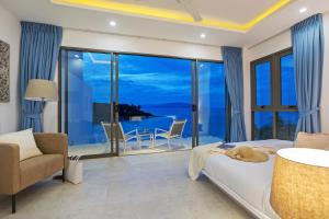 una camera con letto e vista sull'oceano di BEACHSIDE VILLA - B18 - at Bayside Luxury Villas Samrong Bay Beach, 4 BED 5 BATH, SEA & SUNSET VIEWS, only 200m walk to the Beach a Choeng Mon Beach