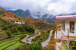 a view of a mountain from a balcony of a house at Zostel Plus Mussoorie- Kempty in Mussoorie
