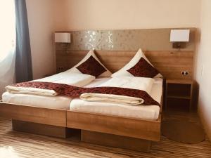 a bedroom with a large bed with a wooden headboard at Gasthof zur Post in Zwiefalten