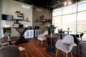 a restaurant with tables and chairs in a room at RedDoorz Plus near Universitas Sumatera Utara in Medan