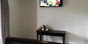 a room with a table and a picture on the wall at Calla Lily Guesthouse in Nelspruit