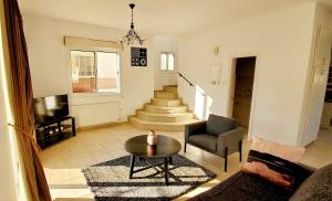 ein Wohnzimmer mit einer Couch und einem Tisch und einer Treppe in der Unterkunft Villa Rossa in Pissouri + 56 Fotos