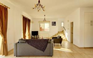 ein Wohnzimmer mit einer Couch und einer Treppe in der Unterkunft Villa Rossa in Pissouri