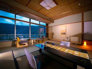 Habitación con mesa, sillas y ventana grande. en Iwakuni Kokusai Kanko Hotel, en Iwakuni