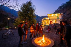 a group of people standing around a fire pit at Zostel Plus Mussoorie- Kempty in Mussoorie