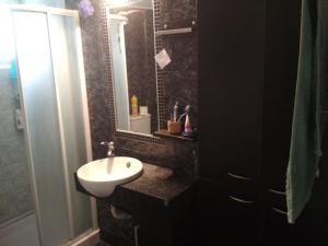 uma casa de banho com um lavatório e um espelho em Blue Maizon em Iráclio