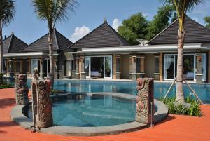 een zwembad voor een huis met palmbomen bij New Horizon Rice Fields & Beach Villas in Bali in Siyut