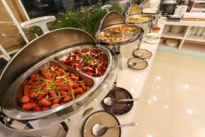 a buffet with several pans of food on a counter at Paseo Premiere Hotel in Santa Rosa