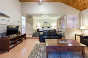 un soggiorno con divano e letto di Bushy Lake Chalets a Margaret River Town