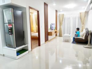a young boy sitting in a living room with a tv at Thanh Xuan Hotel in Vung Tau