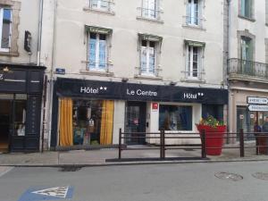 a row of store fronts on a city street at Hôtel Le Centre in Les Herbiers