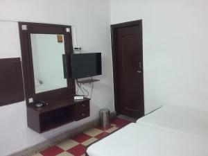 a bedroom with a bed and a mirror and a tv at Hotel Natraj in Rānchī