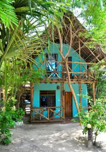 una casa azul con techo de paja en Sagando Bungalows Zanzibar, en Michamvi