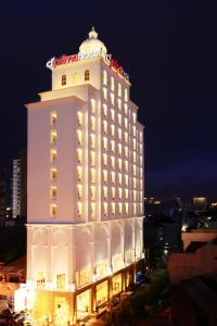 un gran edificio blanco con un cartel de hotel encima en d'primahotel Pattimura Makassar en Makassar