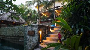 a set of stairs leading to a building with lights at Kori Ubud Resort, Restaurant & Spa in Ubud