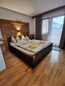 um quarto com uma cama grande e uma cabeceira em madeira em Ferienwohnung Brugger em Zellberg